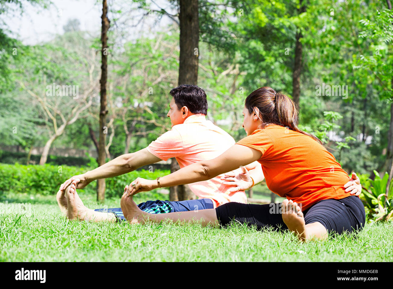 Deux Couple Doing Yoga étirement Exercice Fitness Workout Souplesse In-Garden Banque D'Images