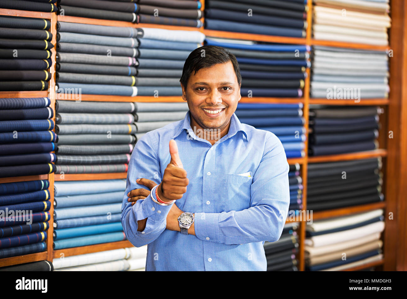 Un vendeur Vente de vêtements Affichage Thumbs-up Shopping clothes store Banque D'Images