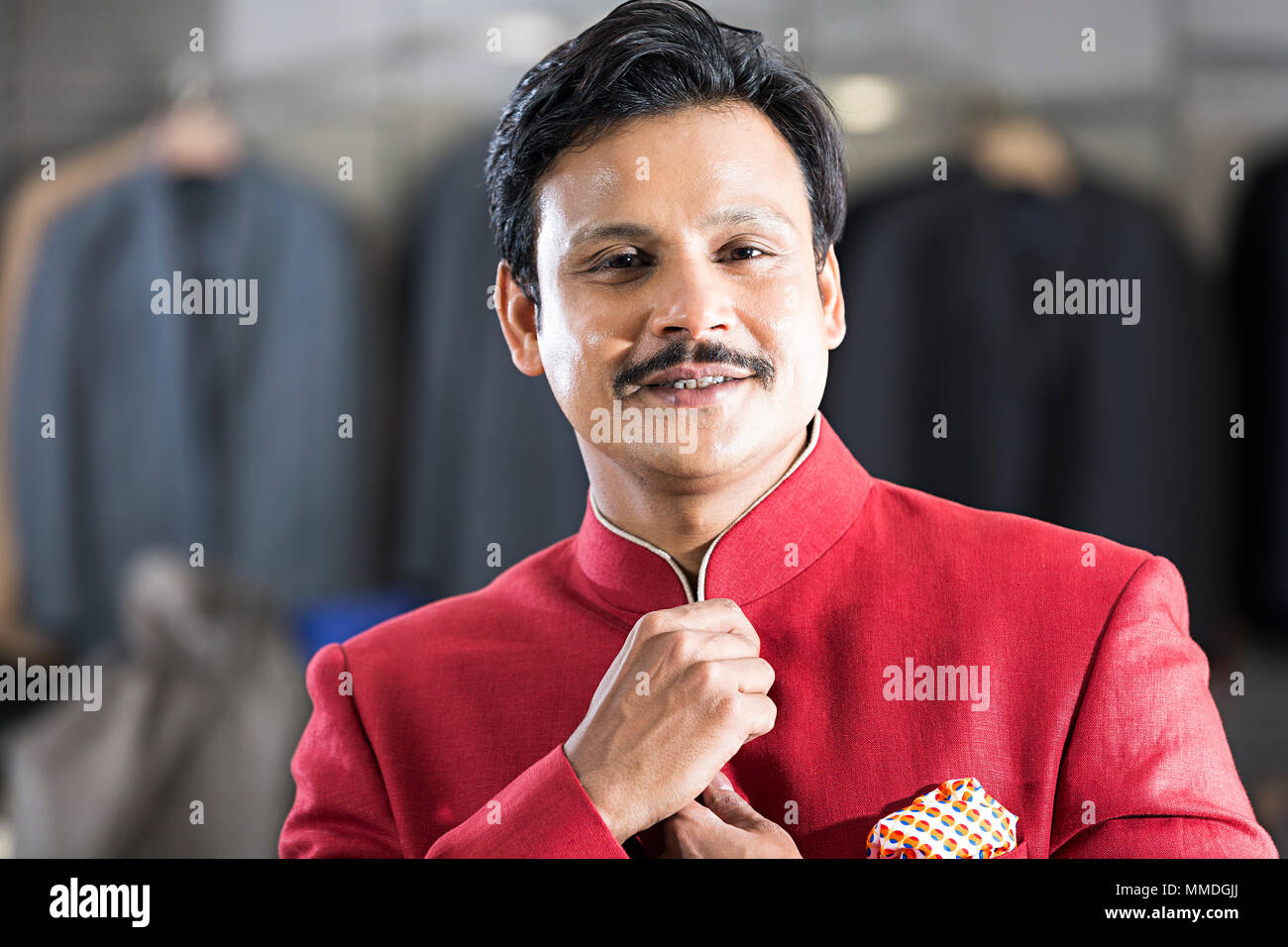 Un Adult-Man souriant essayant des contrôles sur place Vêtements Sherwani Store Banque D'Images