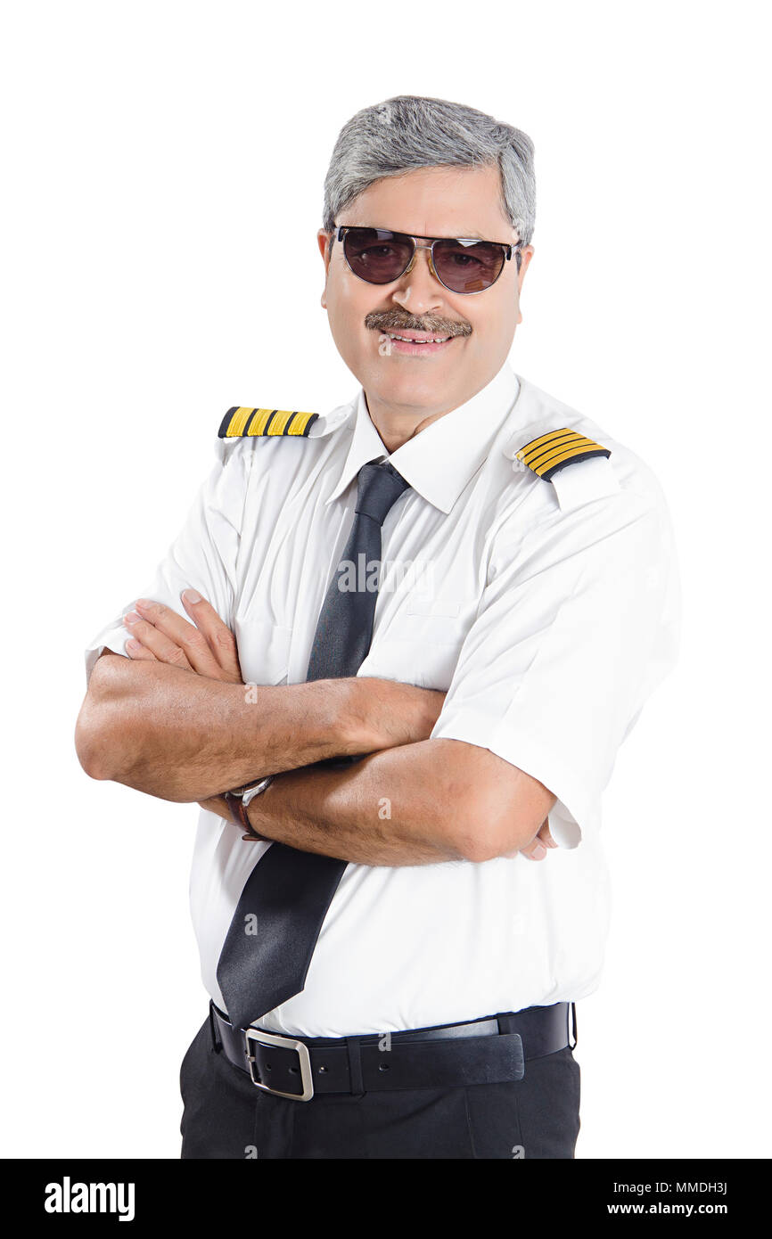 Un Senior Man In-Pilot Crossed-Arms uniforme avec fond blanc permanent Banque D'Images