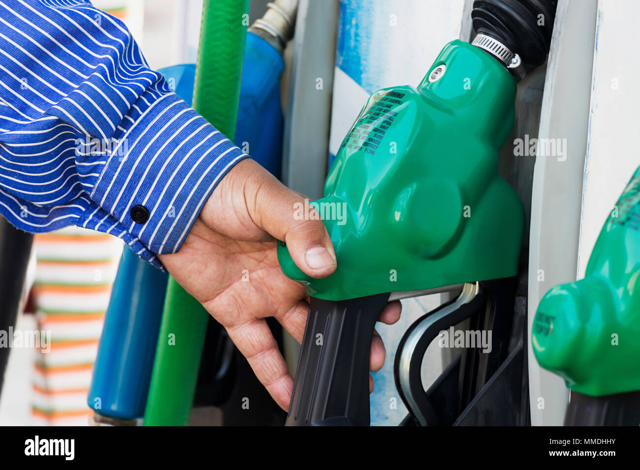 Close-up l'un employé de sexe masculin hand Holding Tuyau de carburant en station service Banque D'Images