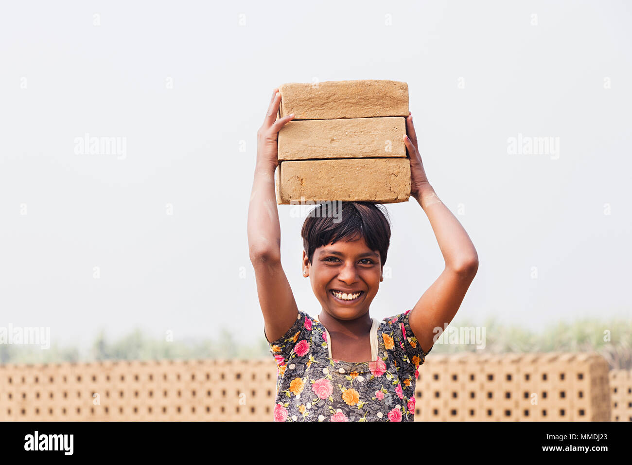 Petite fille Worker Carrying stacks Bicks sur sa tête -Brique Factory Banque D'Images