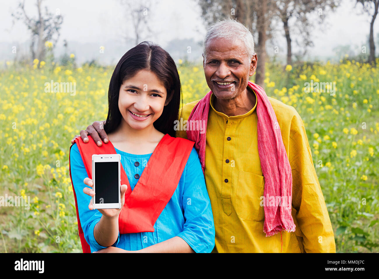 Villageois Rural, grand-père et l'Adolescente montrant Téléphone mobile J'In-Farm Banque D'Images