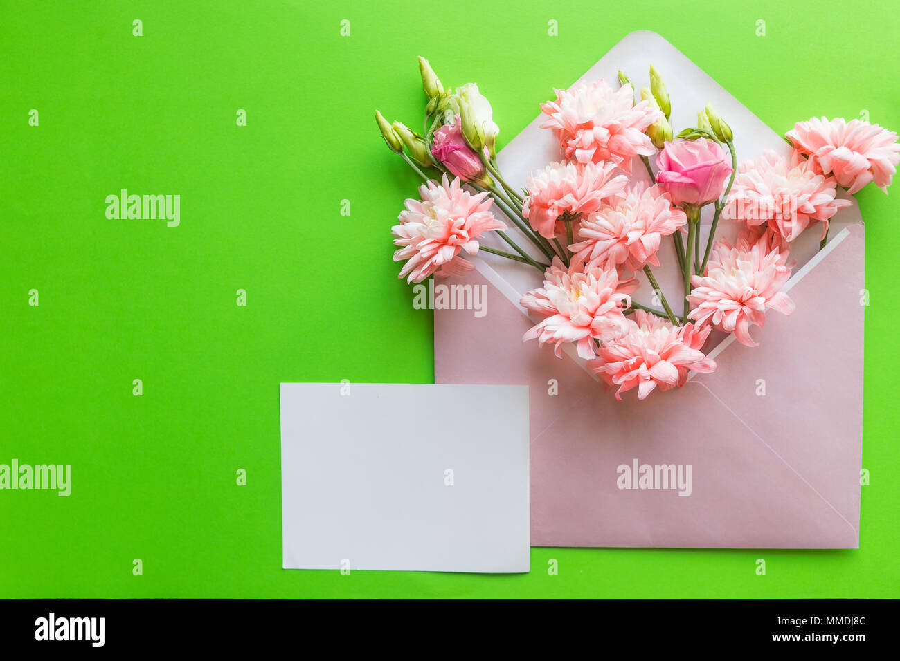 Concept de la Fête des mères. Bouquet de lisianthus roses, des chrysanthèmes avec enveloppe. Remarque pour le papier vierge copie espace.carte dans la fête des mères, mariage, anniversaire ou un remplissage de mot dans l'occasion spéciale Banque D'Images