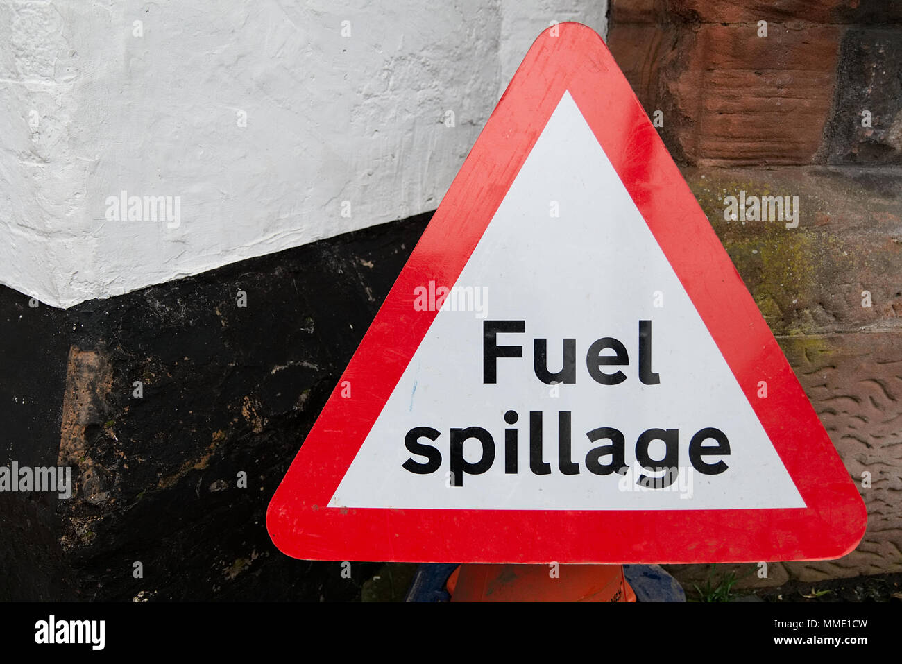 Triangulaire rouge et la sécurité routière les déversements de carburant avertissement signe un texte noir sur fond blanc contre wall with copy space Banque D'Images