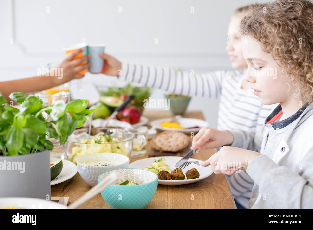 Boy eating falafel lors d'anniversaire à la maison. Régime alimentaire sain pour les enfants Banque D'Images