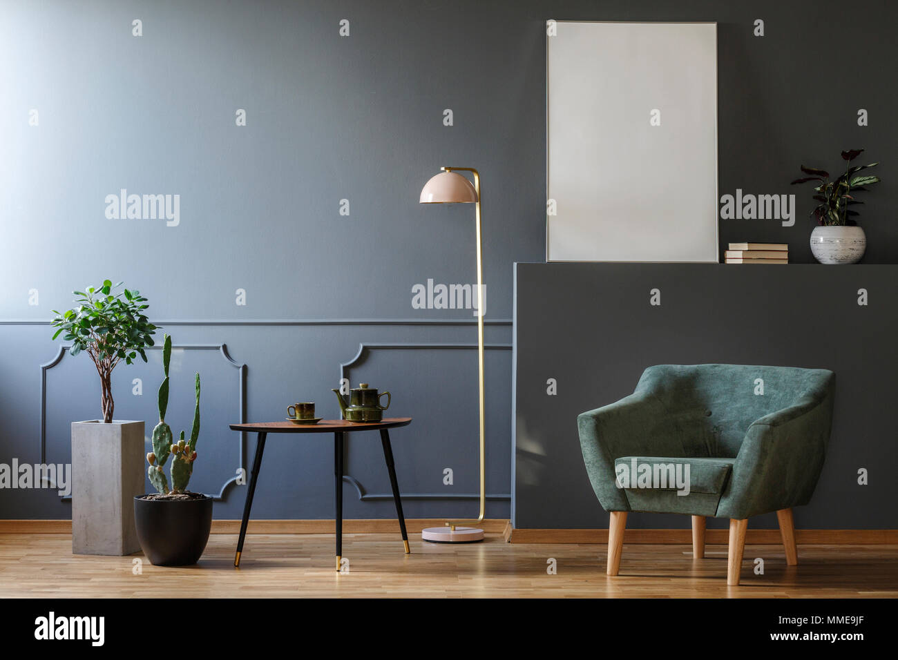 Le tableau entre les plantes et la lampe en gris vacances intérieur avec un fauteuil vert et immersive Banque D'Images