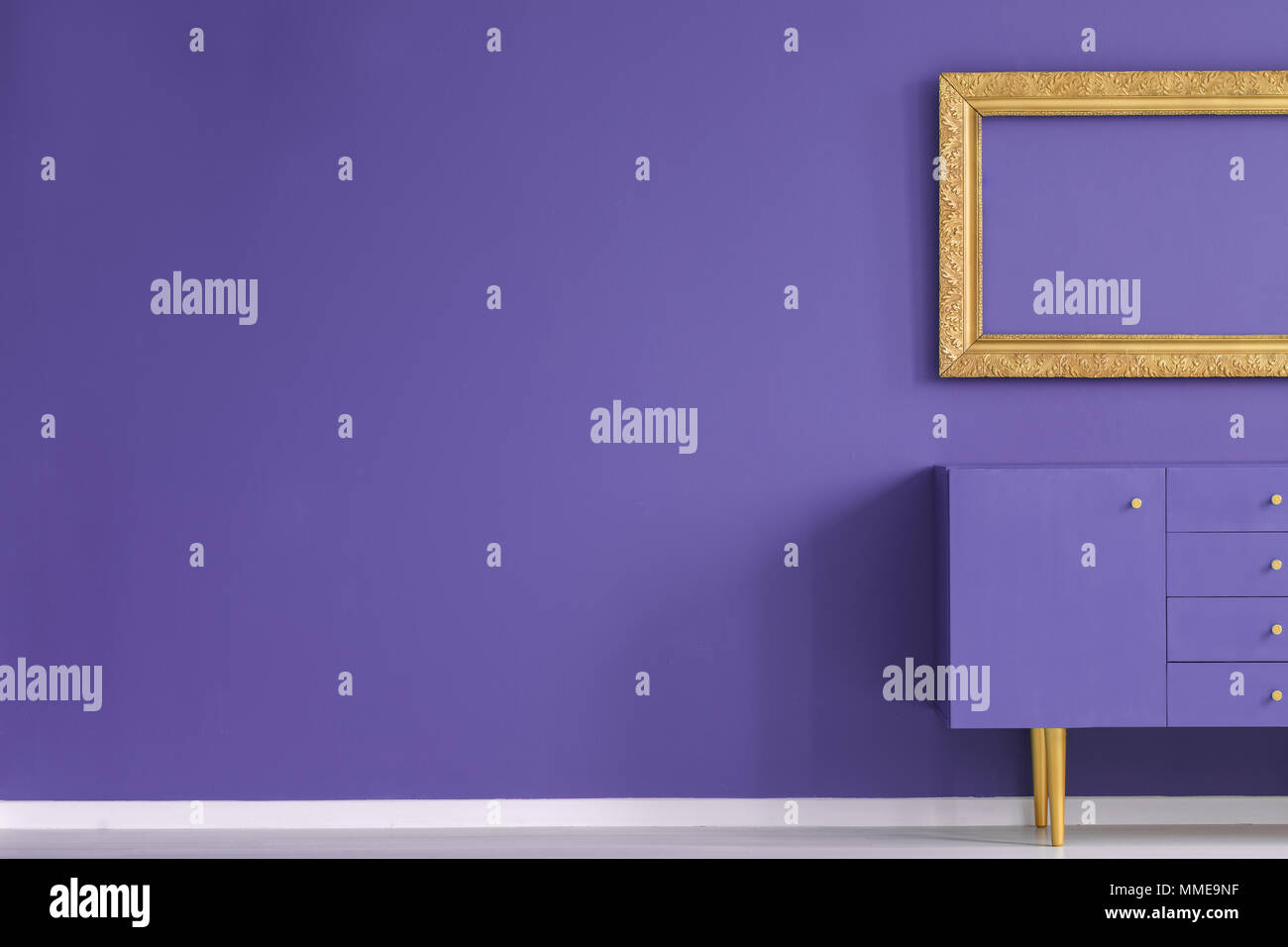 Véritable photo d'un salon créatif intérieur avec cadre doré au-dessus de l'armoire violette se tenir contre un mur vide avec copie espace. Pour vos p Banque D'Images