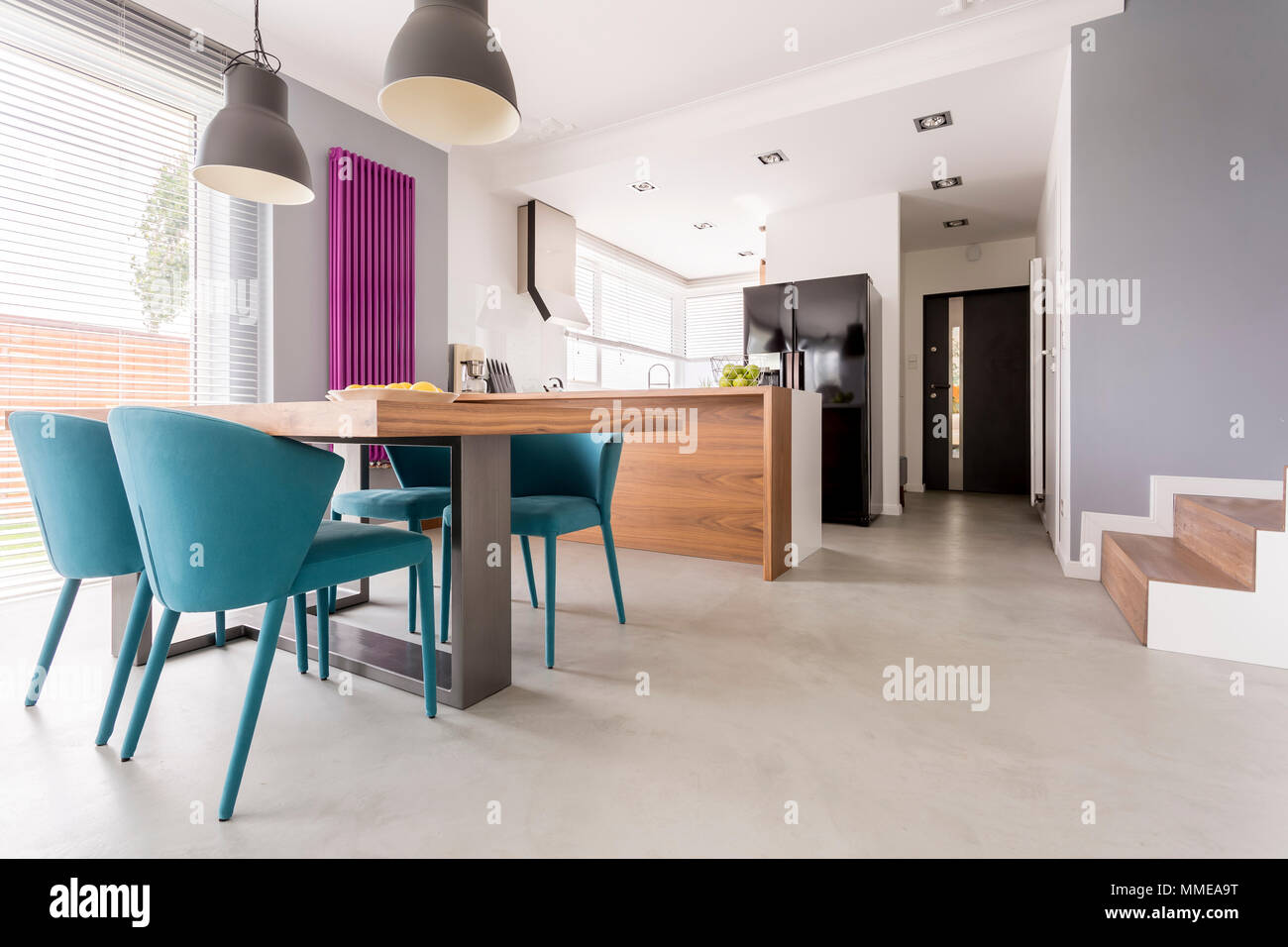 Cet appartement décloisonné moderne monochromatiques avec des accents en bois et en salle à manger et cuisine avec escalier et l'entrée de porte Banque D'Images