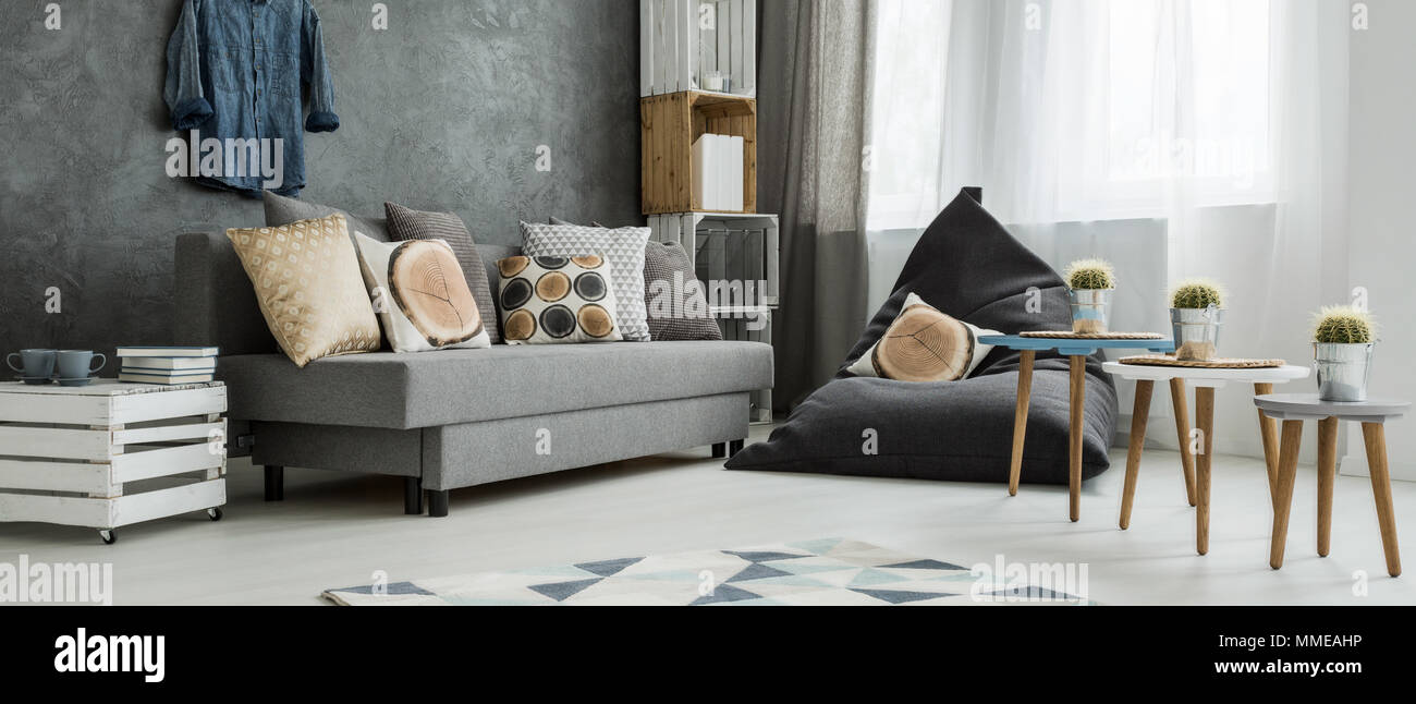 Coin gris d'un appartement moderne, avec un canapé confortable et d'un coin sac avec oreillers en imitant des troncs de bois Banque D'Images