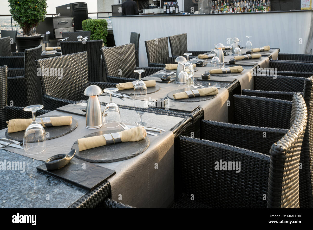 Tourné d'une table de restaurant avec des verres vides et une plaque avec une serviette sur le dessus dans un bar sur le toit du restaurant. Banque D'Images Tourné d'une table de restaurant avec des verres vides et une plaque avec une serviette sur le dessus dans un bar sur le toit du restaurant. Banque D'Images