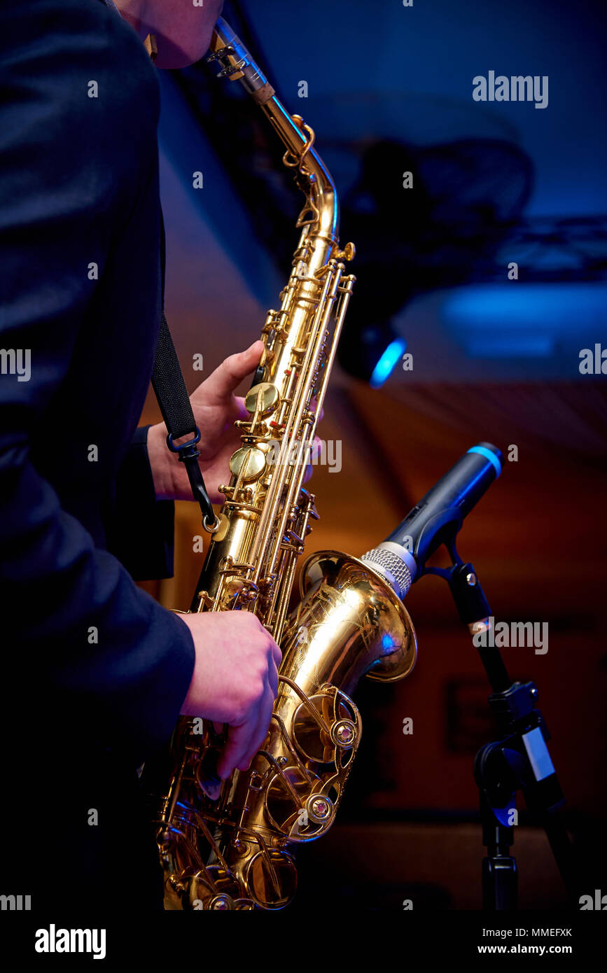 Saxophone dans les mains d'un musicien près du microphone Banque D'Images