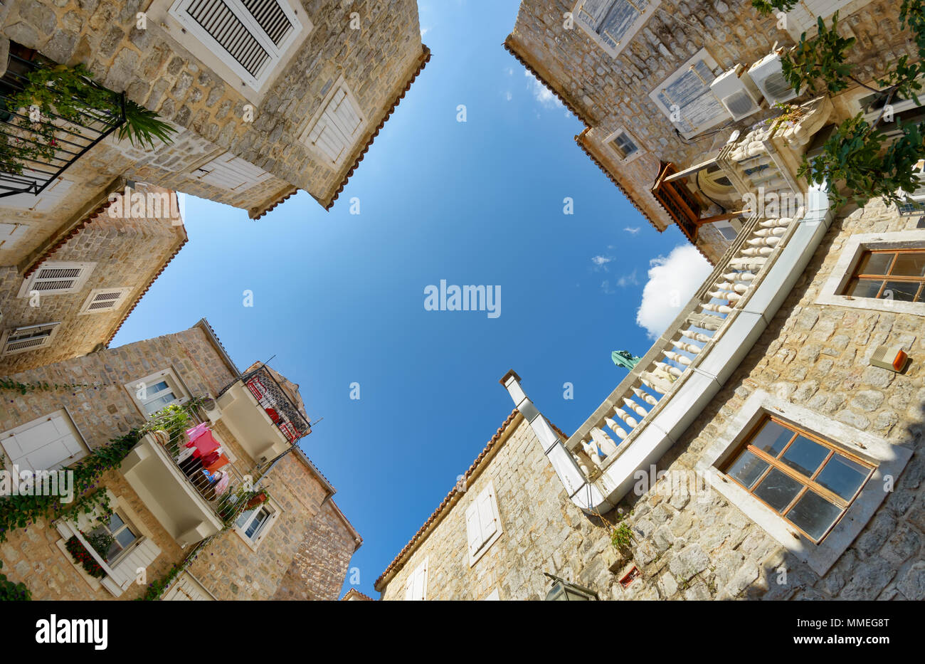 Petite place pittoresque avec des maisons en pierre de la vieille ville de Budva, grand angle vue de bas en haut avec ciel bleu, l'Europe des Balkans Monténégro Banque D'Images