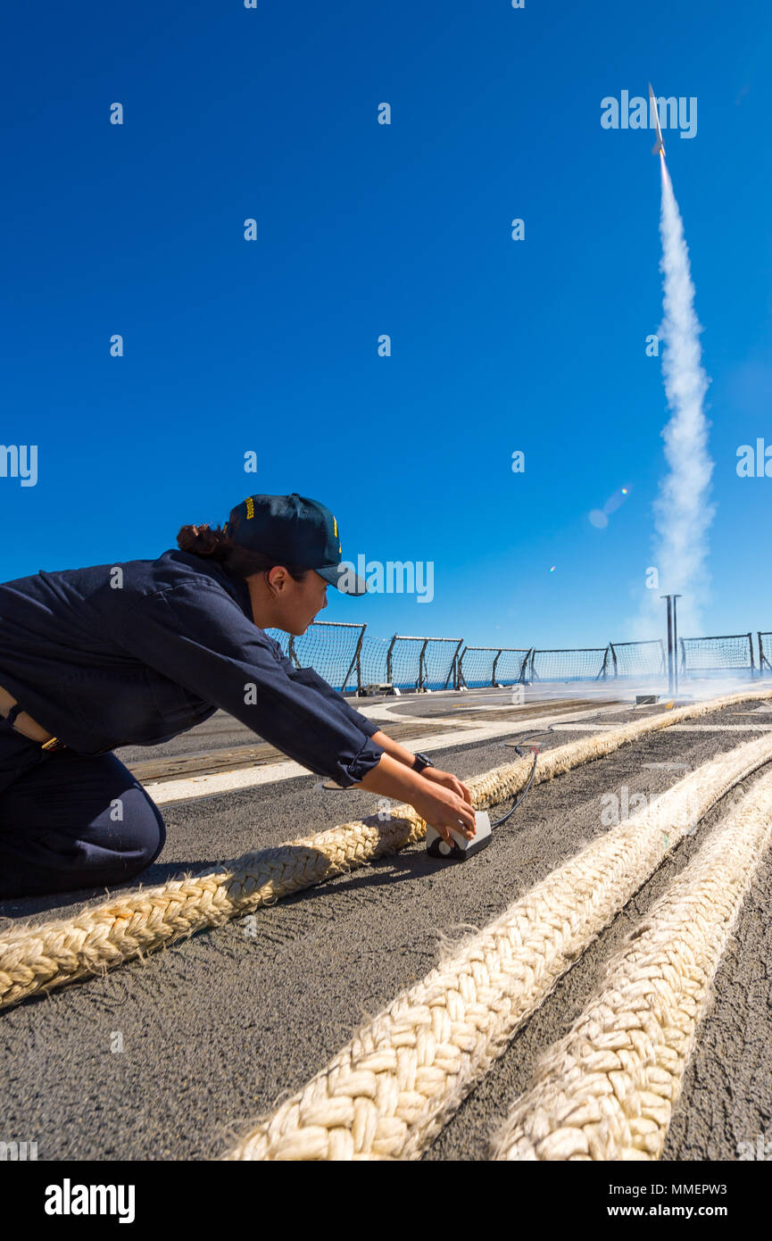 171023-N-KT595-504 OCÉAN PACIFIQUE (oct. 23, 2017) Le lieutenant Rose Witt, le croiseur lance-missiles USS Mobile Bay (CG 53) Officier d'approvisionnement, aide à lancer une fusée sonde depuis la cabine de pilotage du navire. La baie de Mobile est actuellement en cours de test d'une ligne de base 9 AEGIS mise à niveau de son système de combat de base 8 en préparation pour son prochain déploiement. (U.S Navy Photo by Mass Communication Specialist 1re classe Tchad M. Butler/libérés) Banque D'Images