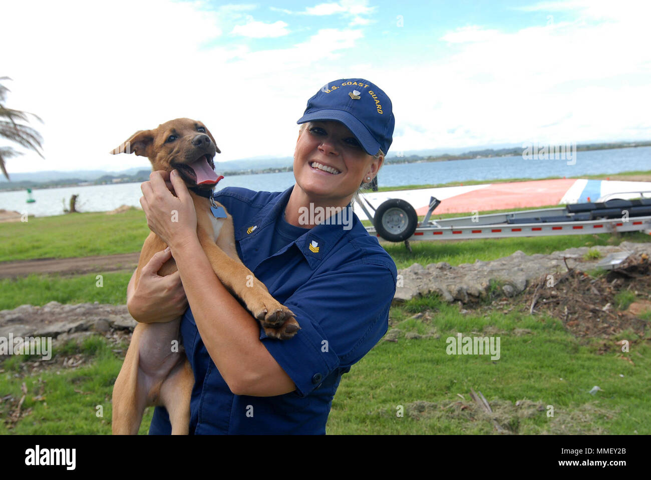 Maître de 1re classe Jana James joue avec son nouveau chien sauvé, Trooper, sur la pelouse du Secteur de San Juan, Porto Rico, le 28 octobre 2018. James, un réserviste de l'unité de la Sécurité maritime de Savannah, Géorgie, déployé à San Juan pour 60 jours à l'appui de l'Ouragan Maria réponse. U.S. Coast Guard photo de Maître de 2e classe Matthieu Masaschi. Banque D'Images