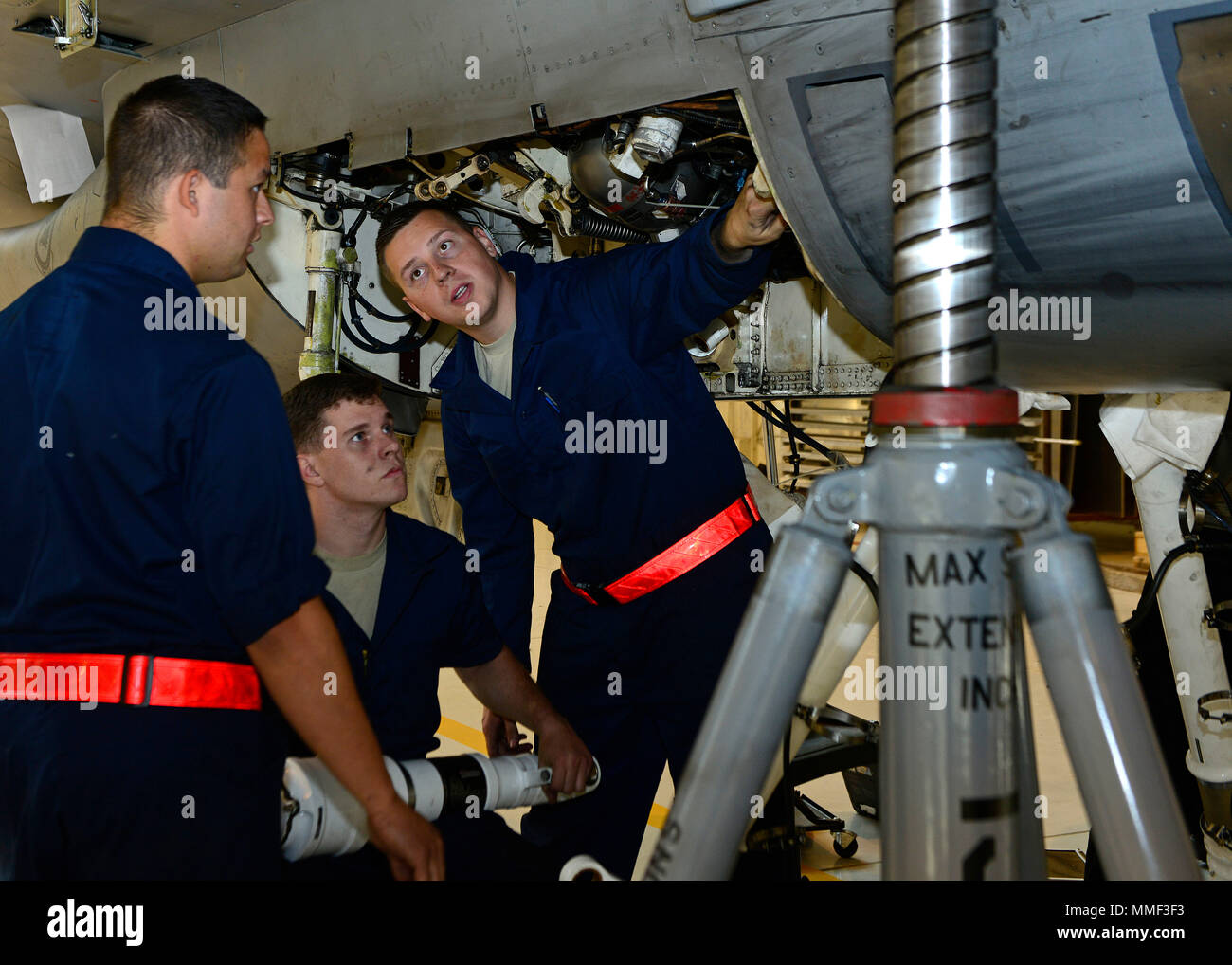 Aviateurs du 31ème escadron de maintenance discuter comment fixer l'amortisseur gauche à un F-16 Fighting Falcon 18 oct., 2017, à la base aérienne d'Aviano, en Italie. Il y a trois jambes de choc dans le F-16 qui absorbent l'impact à l'atterrissage. (U.S. Air Force photo par un membre de la 1re classe Ryan Brooks) Banque D'Images