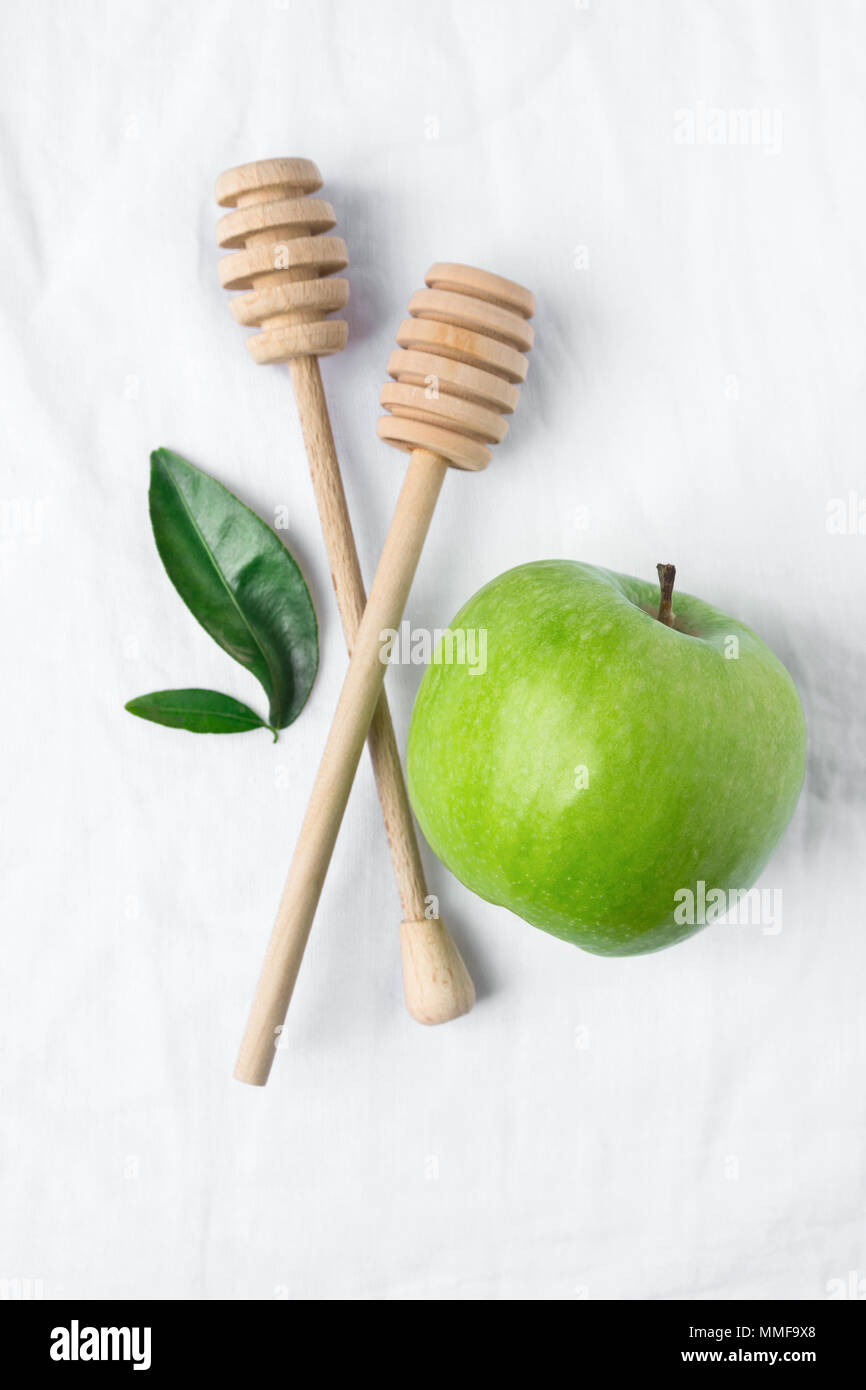 Les balanciers en bois Miel Pomme Verte mûre Feuilles sur fond de toile de lin coton blanc. Mode de vie sain Ayurveda cosmétiques bio Concept de soins de la peau. Banque D'Images