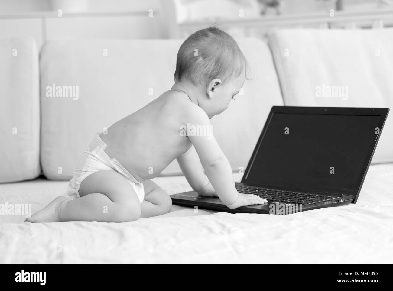 Photo en noir et blanc de l'adorable bébé garçon avec coffre Banque D'Images