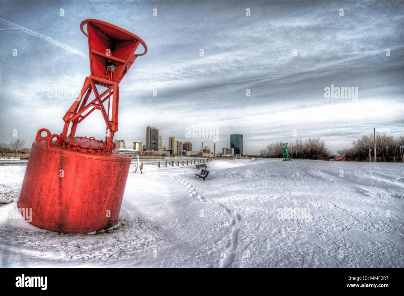 Une vue sur le centre-ville de Toledo Ohio's skyline de partout dans la gelée et la neige rivière Maumee. Une bouée rouge se trouve au premier plan de cette ville portuaire. Banque D'Images