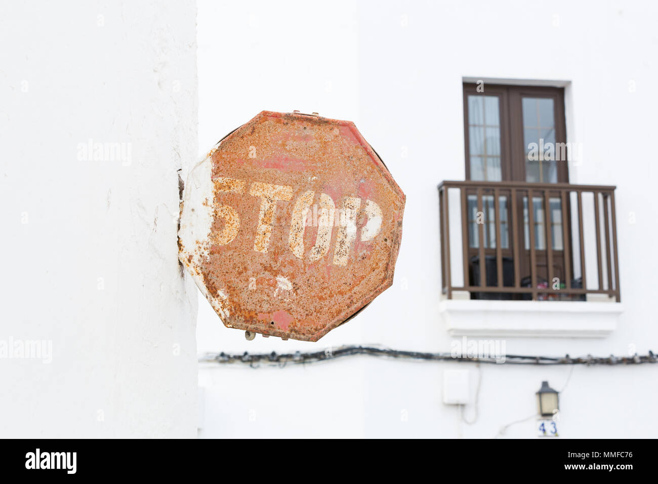 LANZAROTE, Canaries, Espagne, EUROPE : Old rusty et survécu à l'arrêt sur un mur blanc avec un petit balcon à l'arrière-plan. Banque D'Images