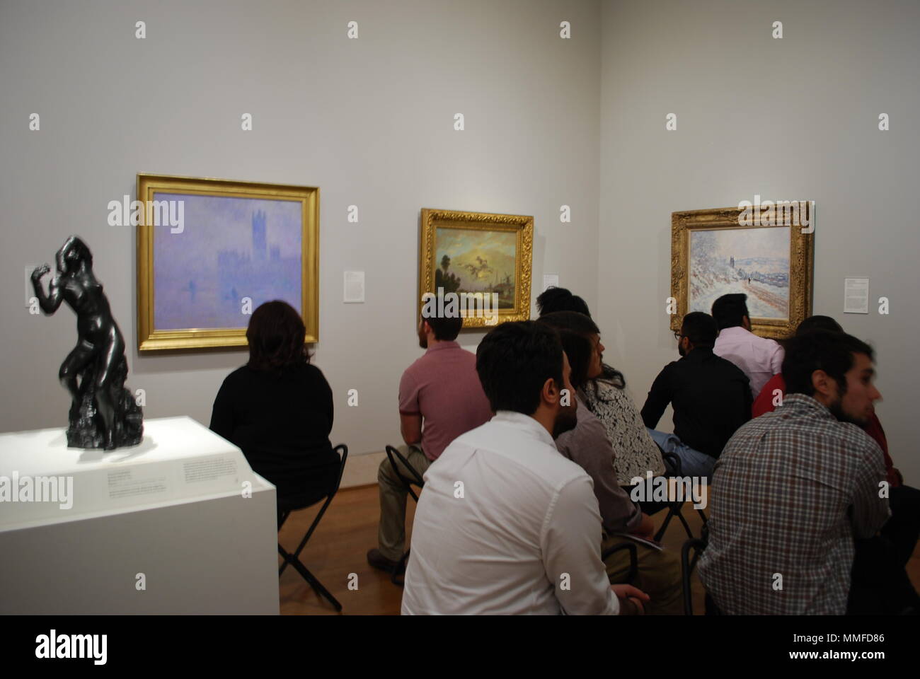 Groupe d'adultes à l'art museum. Les gens assis à regarder la peinture d'art célèbres. Groupe multiracial de la population de l'étude. La curiosité, l'éducation concept. Banque D'Images