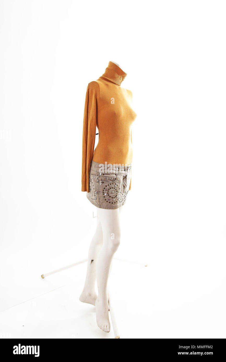 Haut orange et beige mini jupe sur mannequin body shop plein écran. Styles de vêtements, mode femme blanc sur fond de studio.. Banque D'Images