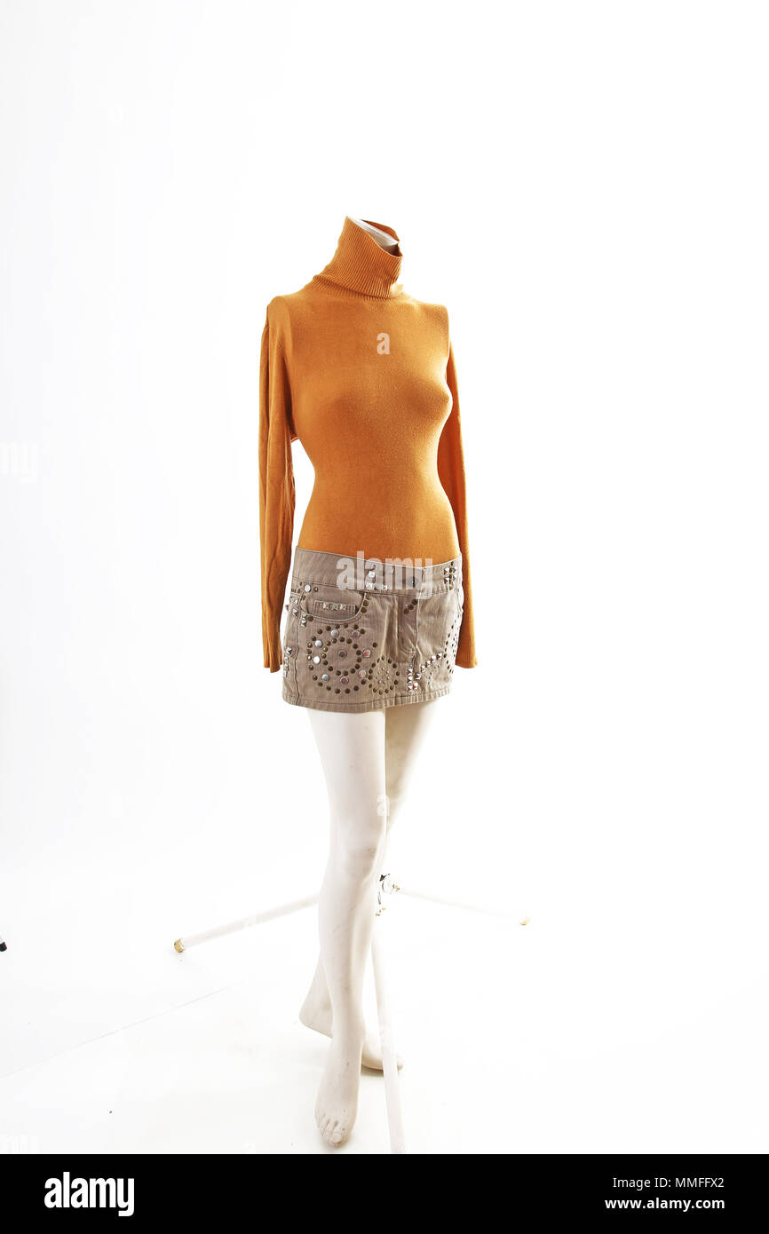 Haut orange et beige mini jupe sur mannequin body shop plein écran. Styles de vêtements, mode femme blanc sur fond de studio. Banque D'Images