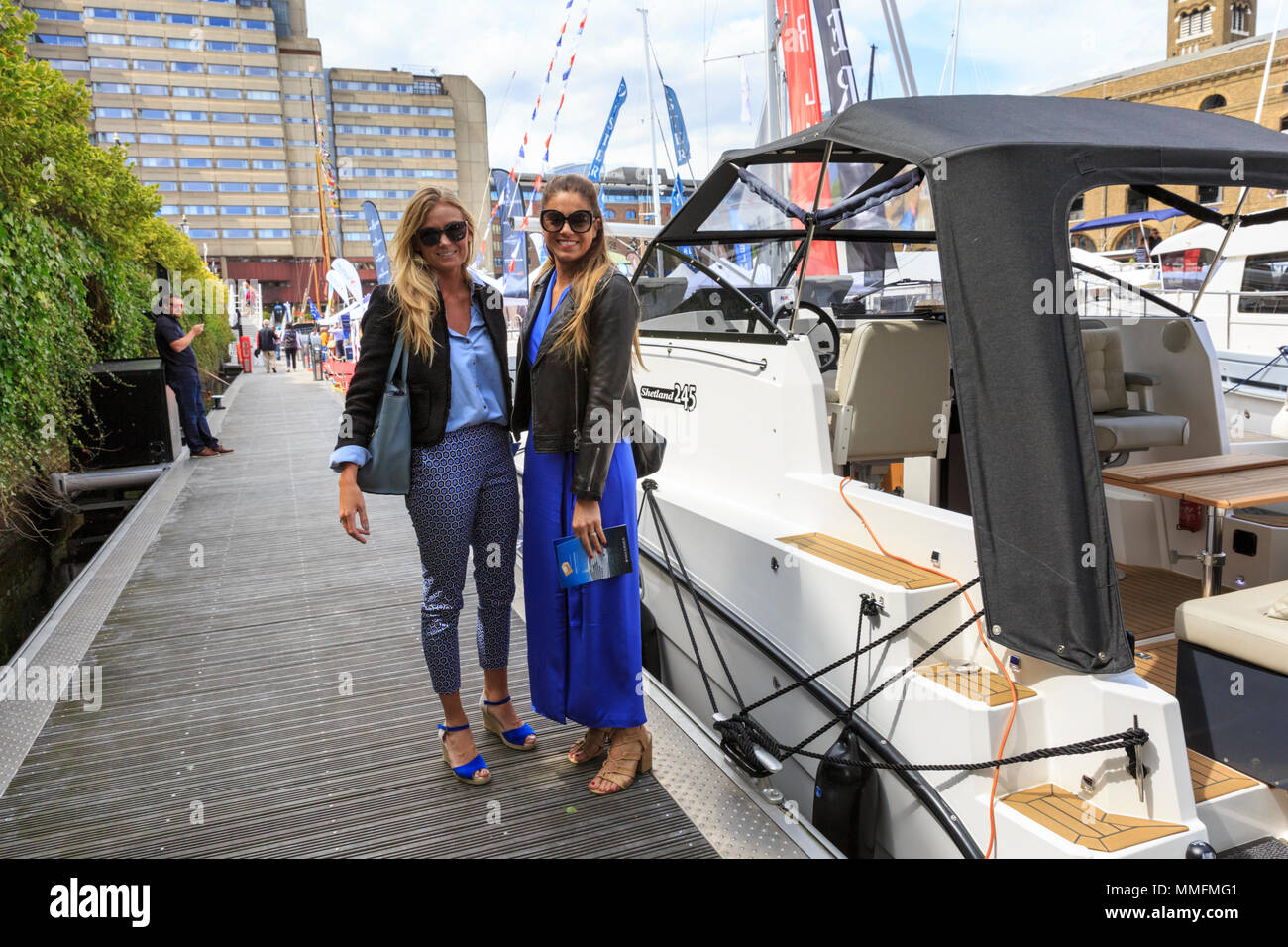 St Katherine Docks, Londres, 11 mai 2018. Deux jeunes femmes profitez d'une promenade dans les yachts de luxe au soleil. Maintenant à sa quatrième année et tenue à l'emblématique marina à côté du coeur de la ville de Londres et du Tower Bridge, Londres est une une un Boat Show et festival, où les yachts, bateaux, voitures et une foule d'autres entreprises peuvent être envisagées à la fois sur l'eau et sur terre. Il s'étend du 10 au 12 mai. Credit : Imageplotter News et Sports/Alamy Live News Banque D'Images