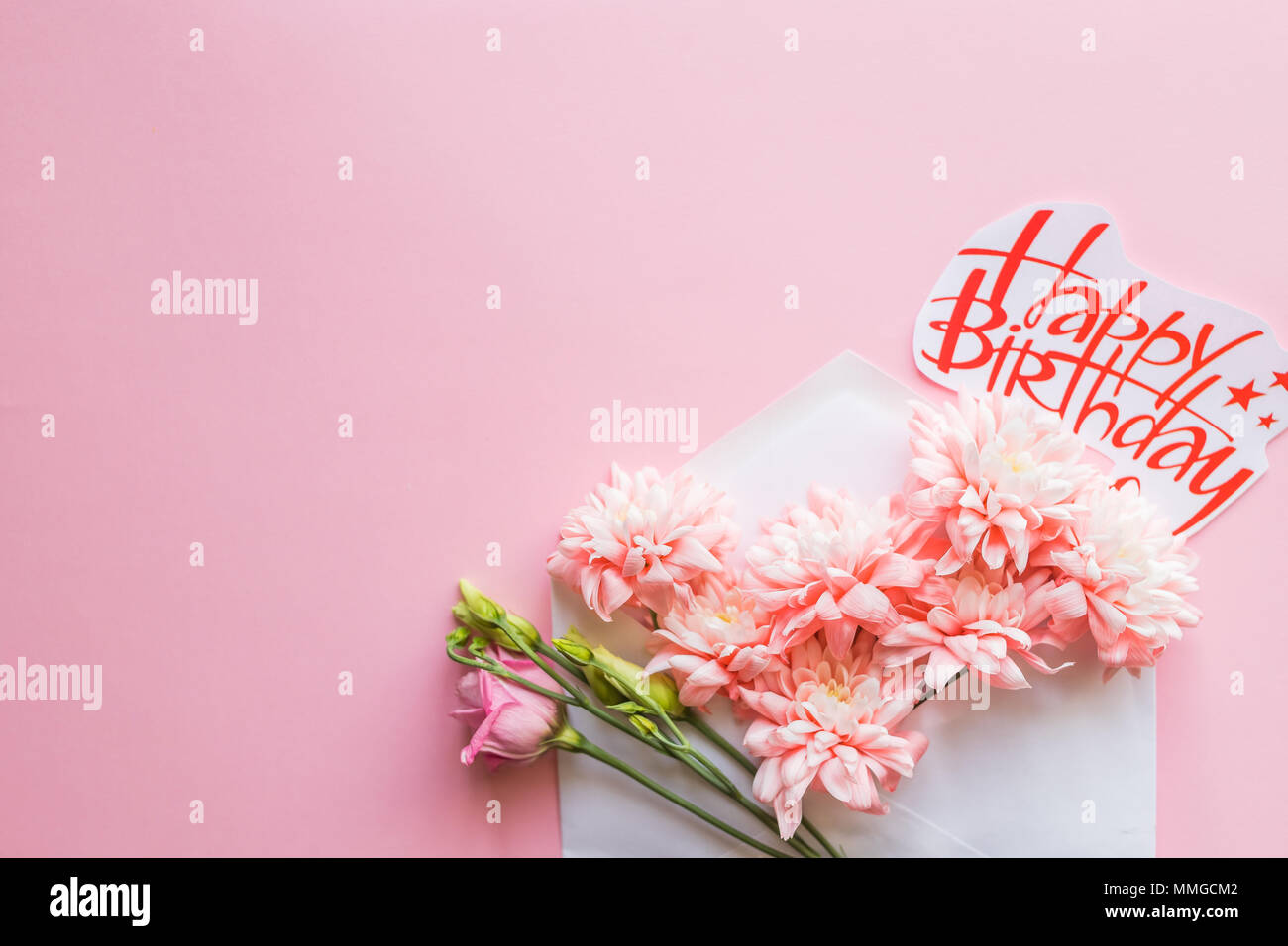Enveloppe blanche avec un arrangement de fleurs de printemps. Mise à plat, vue du dessus.Joyeux Anniversaire carte avec Chrysanthèmes Banque D'Images