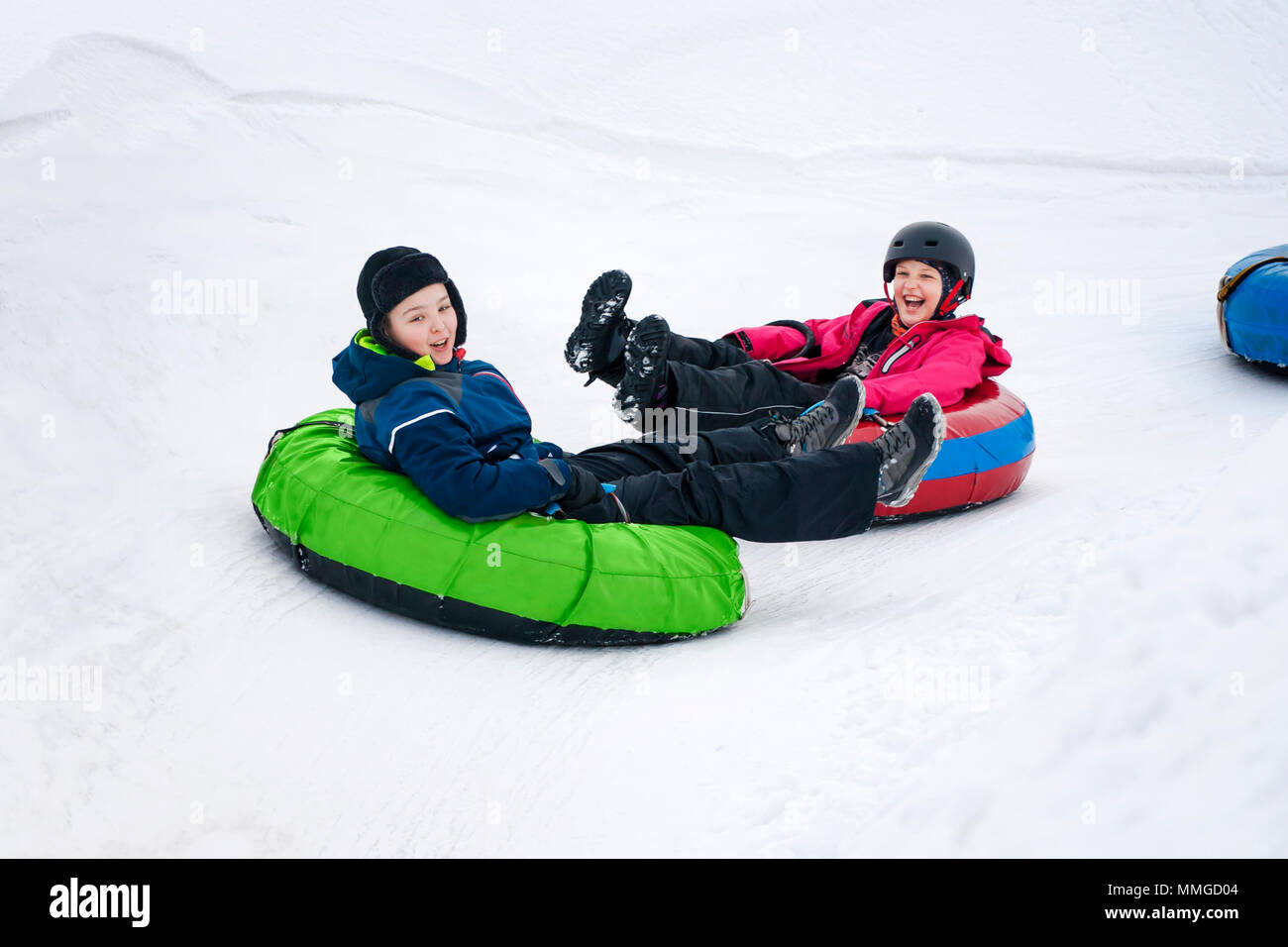 Kids on snow tubes descend une pente à une journée d'hiver. Banque D'Images