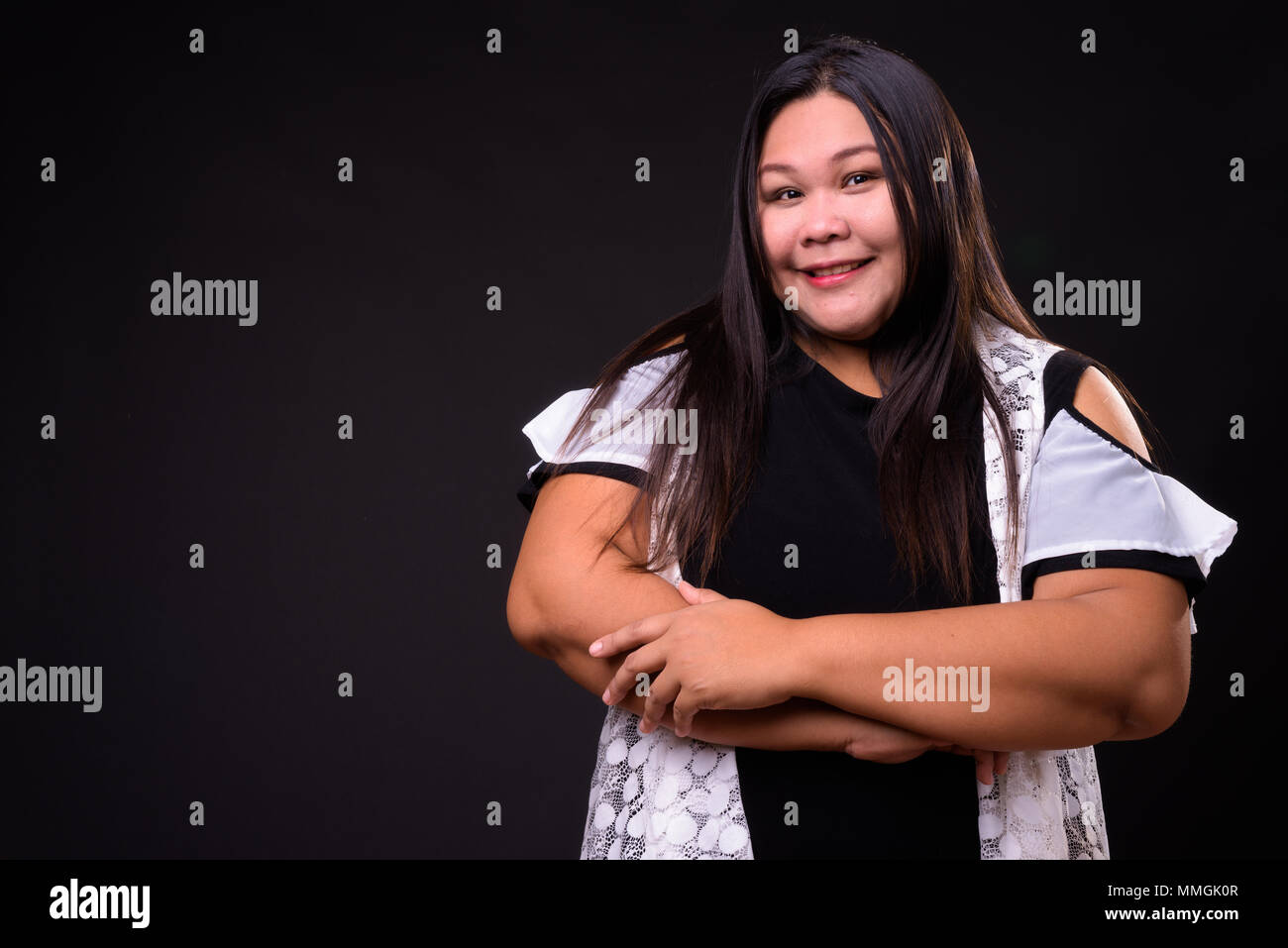 Belle femme asiatique en surpoids sur fond noir Banque D'Images