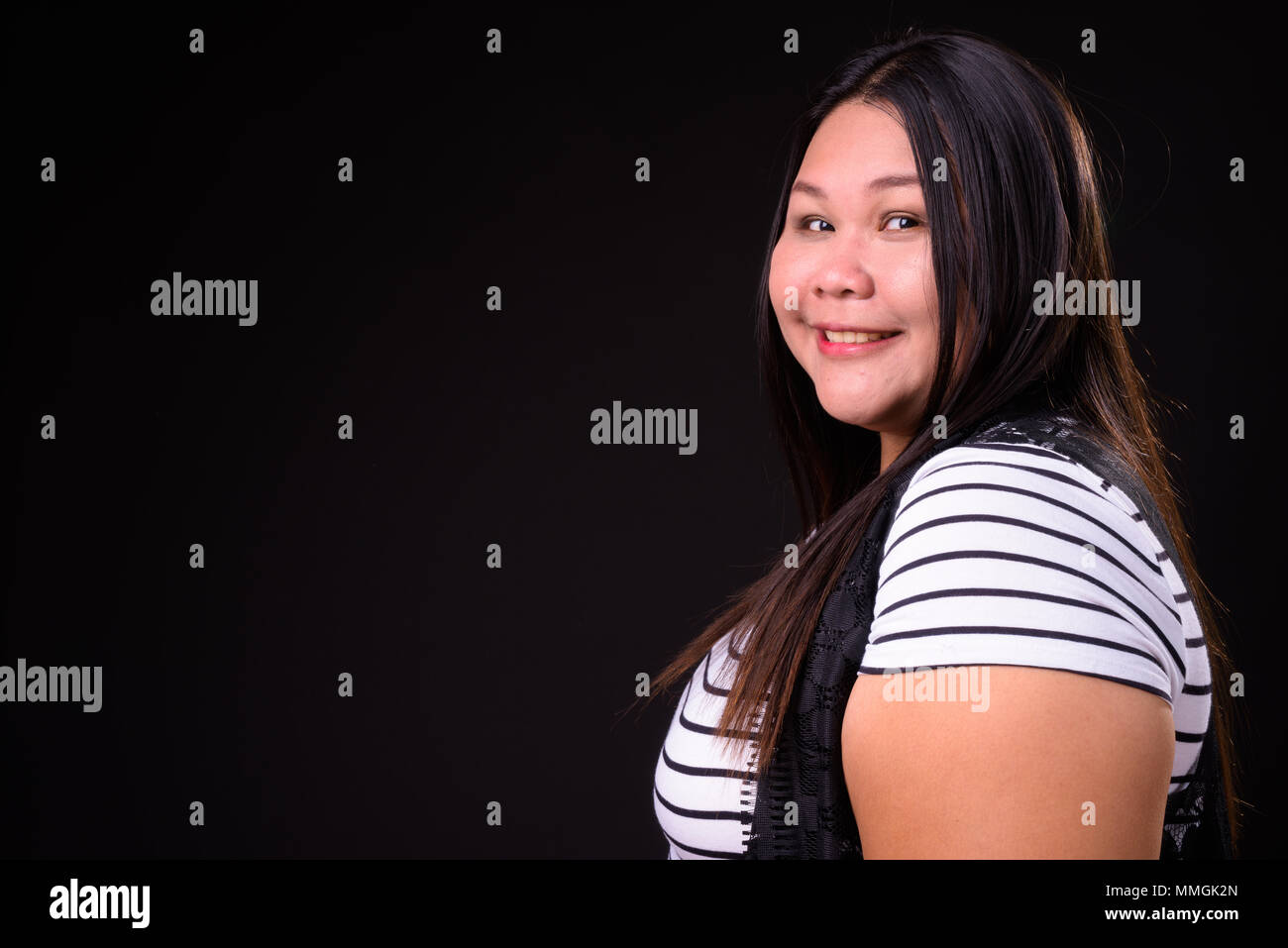 Belle femme asiatique en surpoids sur fond noir Banque D'Images