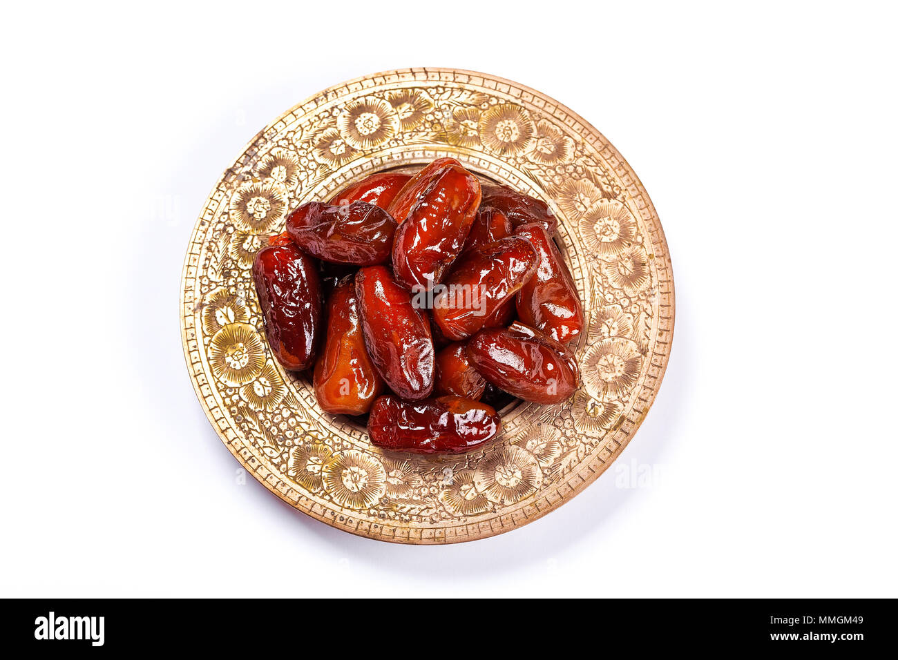 Dattes séchées sur un plateau traditionnel sur un fond blanc. Ramadan Kareem Banque D'Images