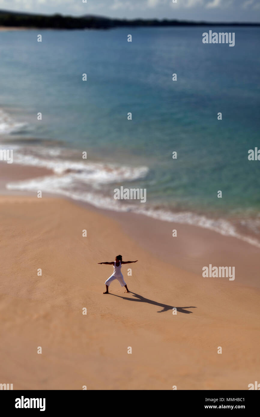 Selective focus on woman practicing yoga at Makena, Maui, Hawaii. Banque D'Images