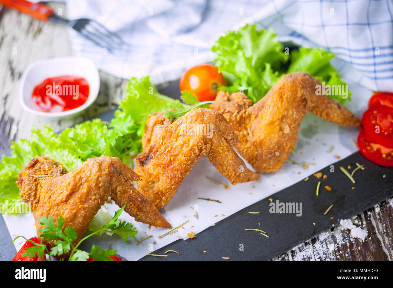 Ailes de poulet frites et ketchup sur fond de bois Banque D'Images