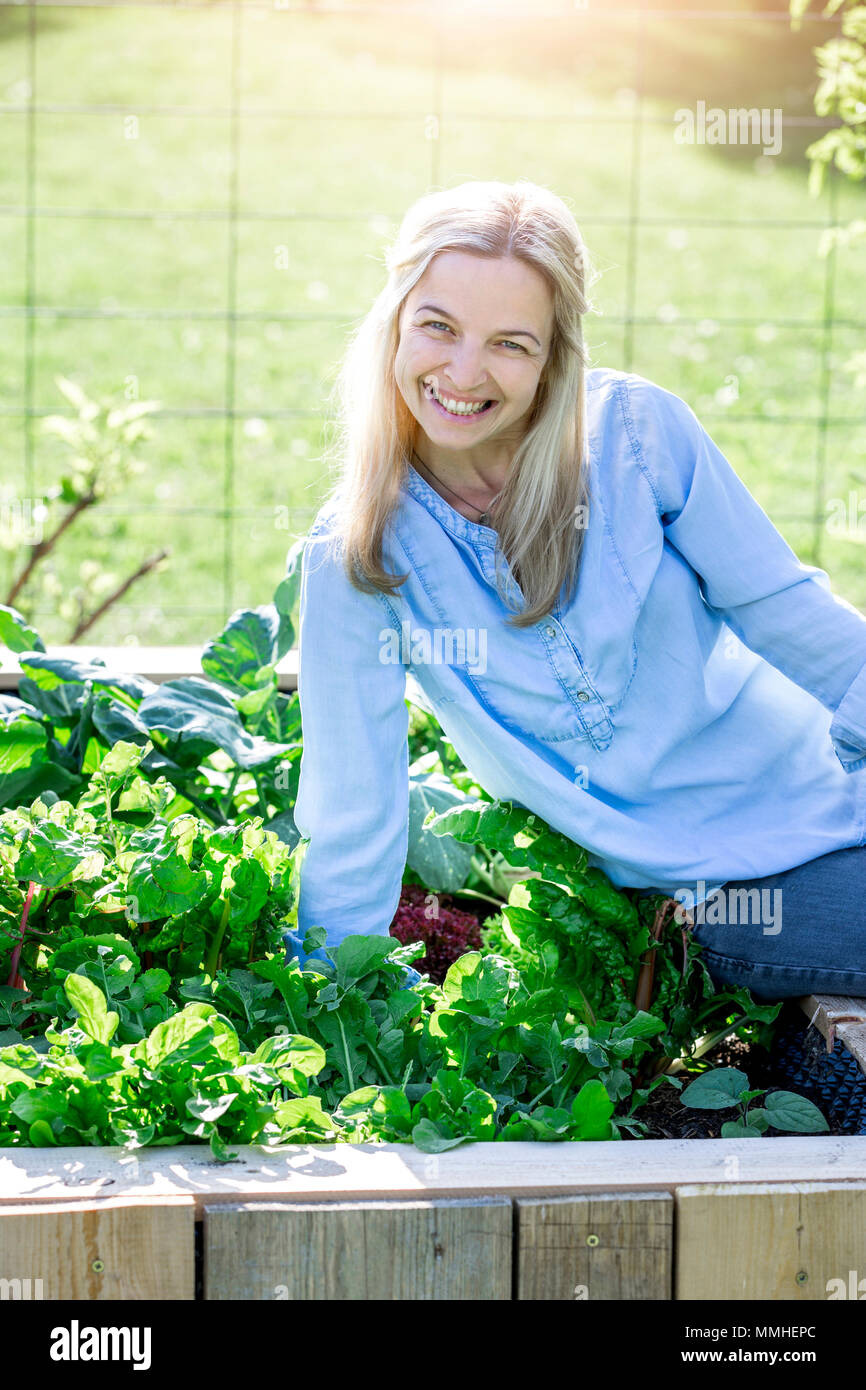 Jardinage - Happy woman est fier de son propre lit soulevé Banque D'Images