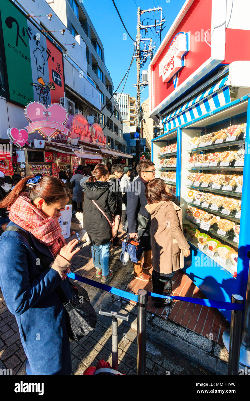 Tokyo, Harajuku, Takeshita street. Marion à emporter à l'extérieur avec store crêpe alimentaire en plastique affichage menu avec les gens à la recherche et le choix. Banque D'Images