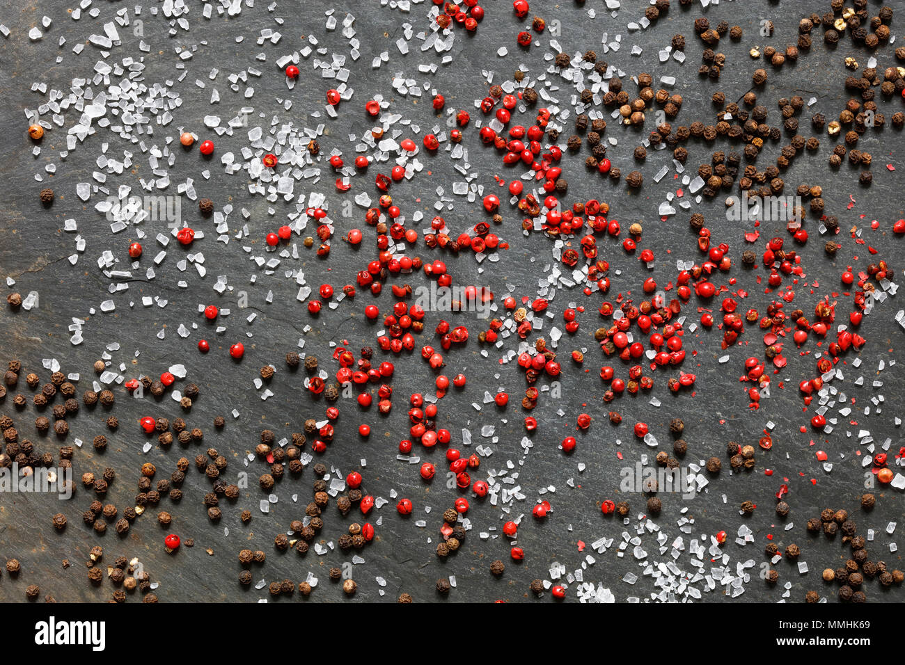 Rock sea salt parsemée de Brown et de poivre rose sur fond d'ardoise Banque D'Images