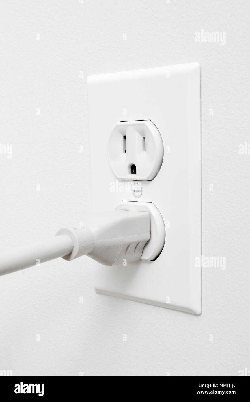 Eco Friendly, l'électricité renouvelable, prise électrique blanc sur mur blanc avec bouchon gris Banque D'Images