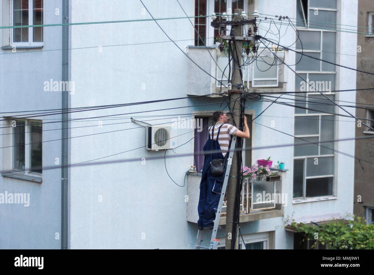 NIS, Serbie - 11 MAI 2018 : travailleur électricien sur l'échelle du système électrique réparation sur l'électricité pilier ou poteau Banque D'Images