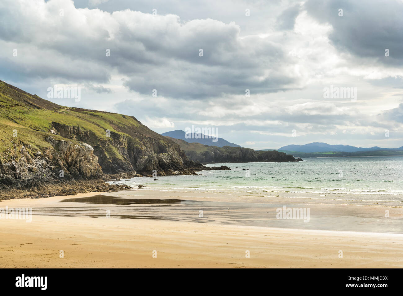 Une plage de sable blanc isolée à Donegal Irlande avec falaises déménagement au loin dans la distance. Banque D'Images