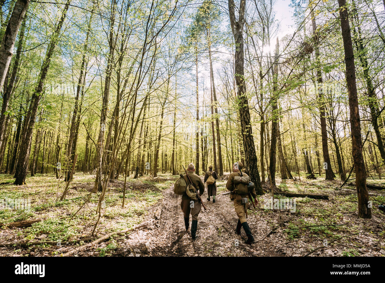 Groupe d'interprètes historiques habillé en russe de l'Armée rouge soviétique, les soldats d'infanterie de la Seconde Guerre mondiale, marchant le long de la Route forestière au printemps. Banque D'Images