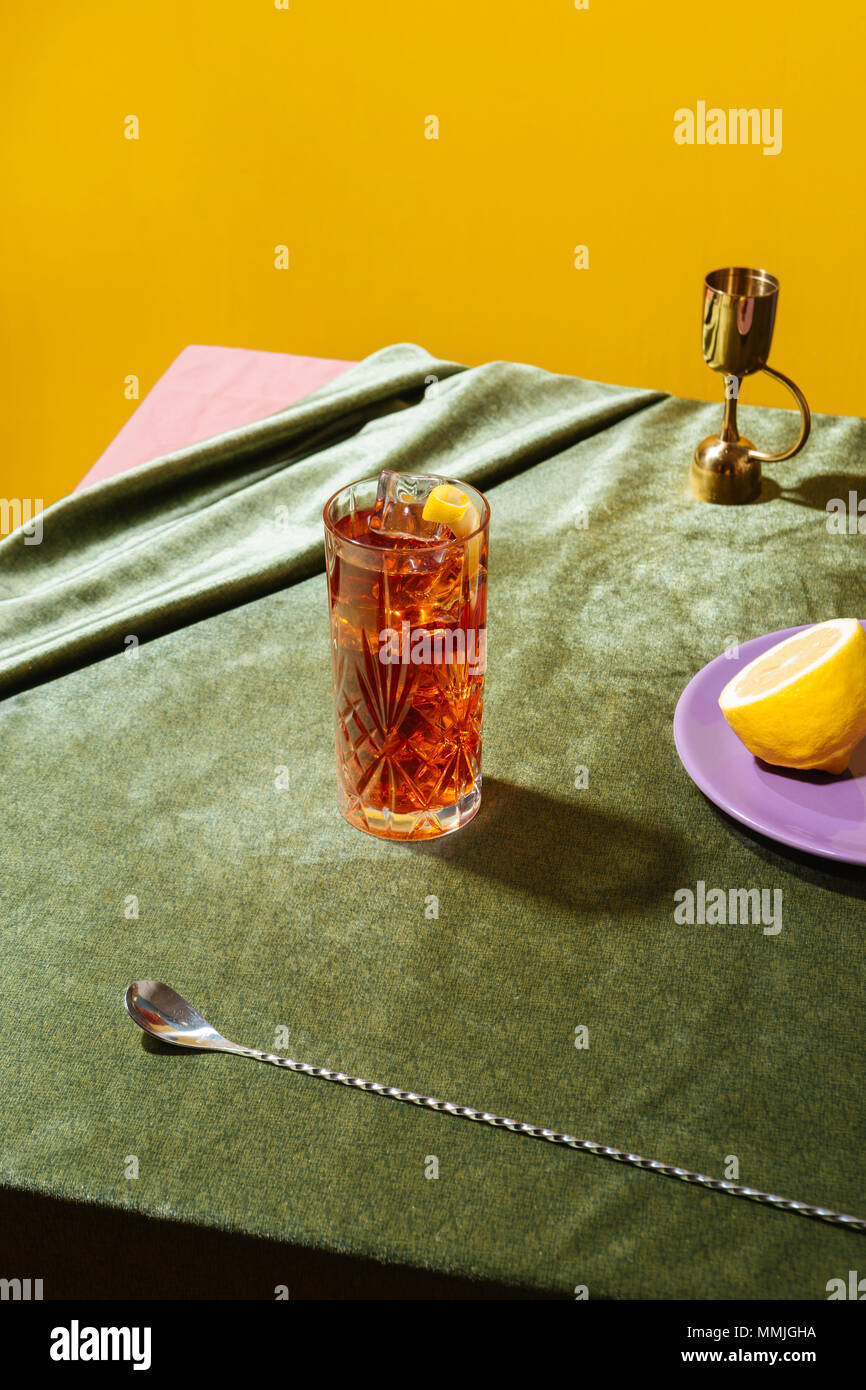 Negroni cocktail, avec l'amer, le vermouth et le gin, sur une table avec nappe de velours pop Banque D'Images