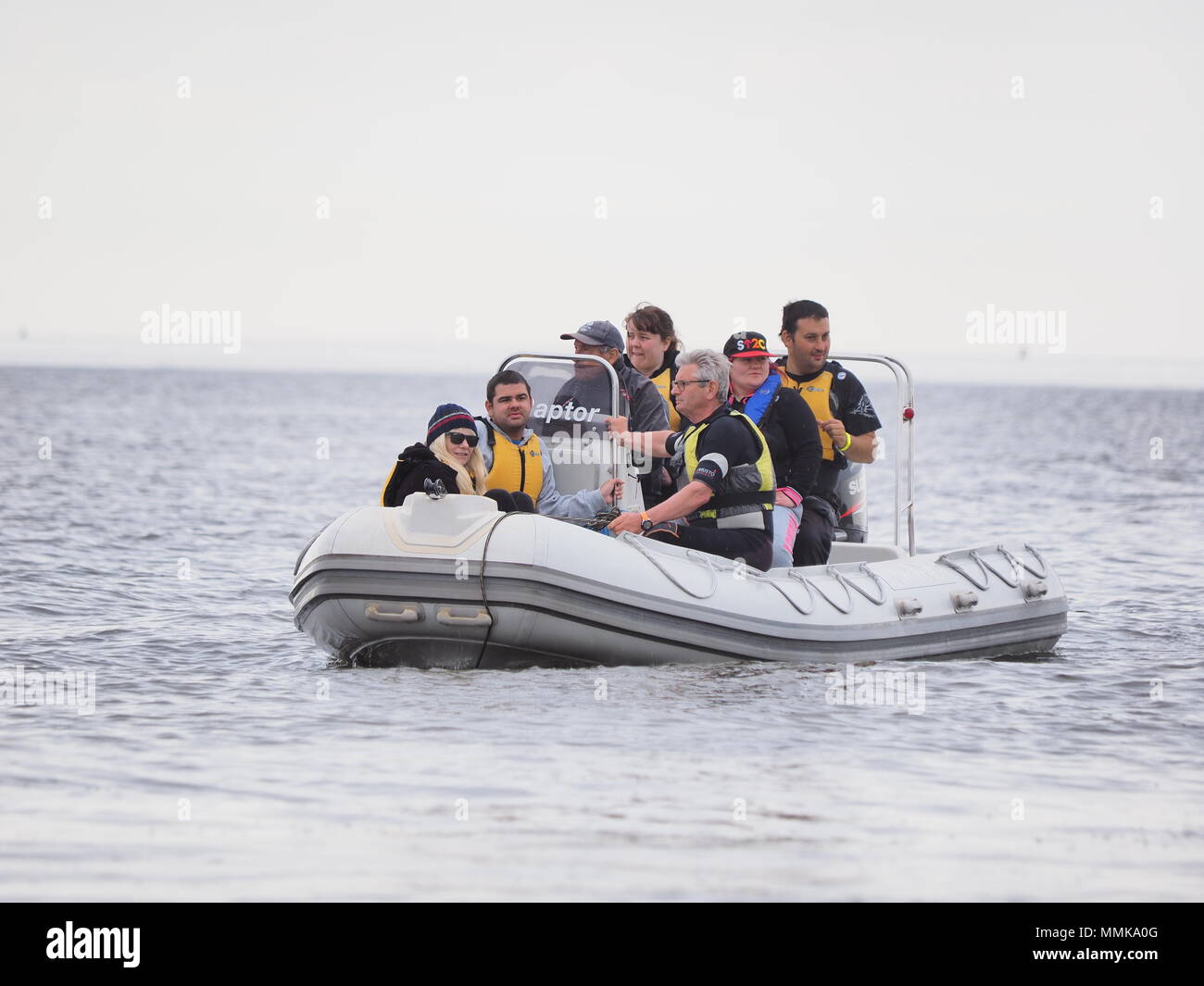 Sheerness, Kent, UK. 12 mai, 2018. Météo France : après un départ lumineux avec des vents légers, des nuages et de la pluie a mis dans pour la Journée Portes Ouvertes à l'île de Sheppey Sailing Club à Sheerness, Kent. La journée portes ouvertes fait partie de la Royal Yachting Association's national 'pousser le bateau en direction de l'initiative des clubs de voile, qui voit à travers le Royaume-Uni tenir des journées portes ouvertes pour présenter les nouveaux venus dans le sport de la voile en mai. Pic : les gens sont pris pour un tour sur un bateau appartenant à l'île de Sheppey Sailability Trust. Credit : James Bell/Alamy Live News Banque D'Images