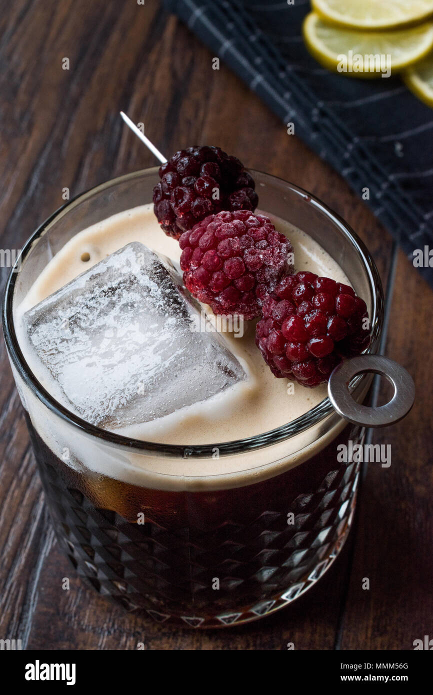 Black / Dark Beer Cocktail avec des mûres et de la glace sur la surface en bois. Concept de boisson. Banque D'Images