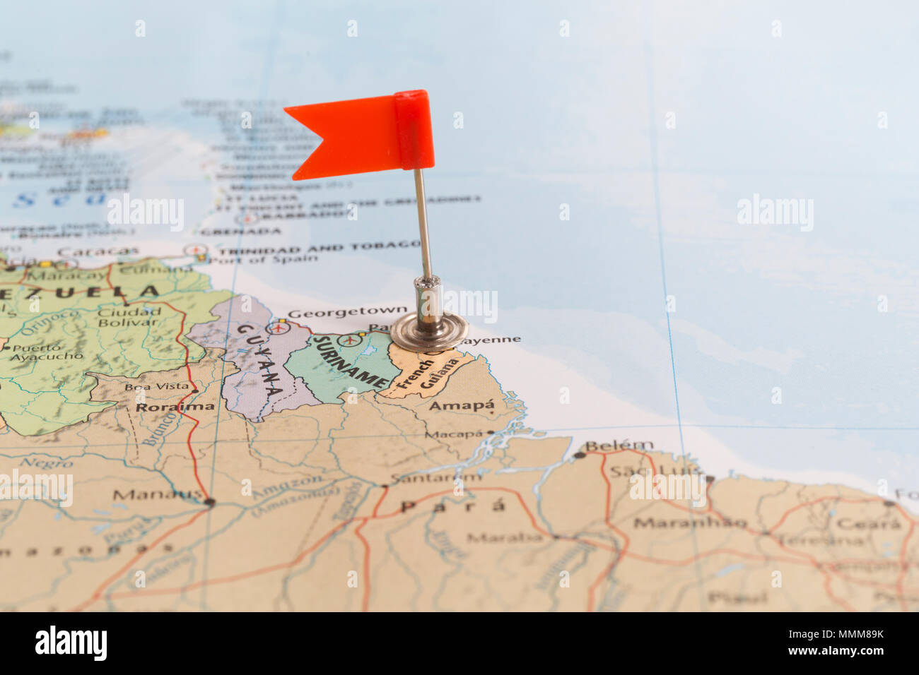 Petit drapeau rouge marquant le pays africain de Guyane sur une carte du monde. Banque D'Images