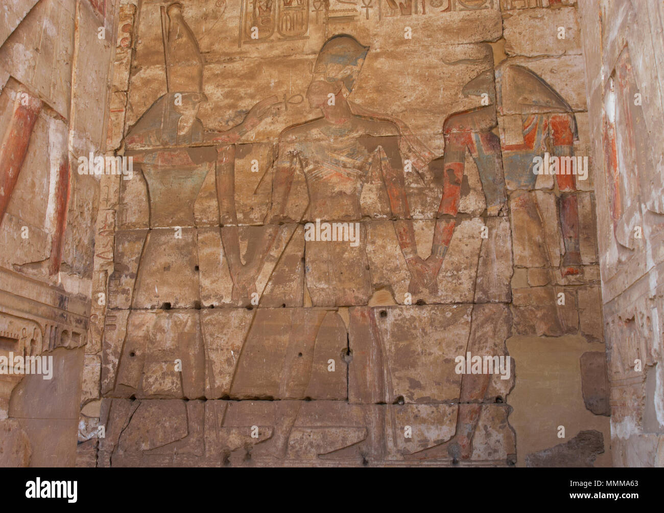 L'Égypte. Abydos. Temple de Seti I. nouveau royaume. 19e dynastie. Soulagement avec polychrome originale représentant le pharaon portant la couronne bleue (Khepresh). À son côté dieux Horus (à gauche) et Khnoum (à droite). 1292-1189 BC. Banque D'Images