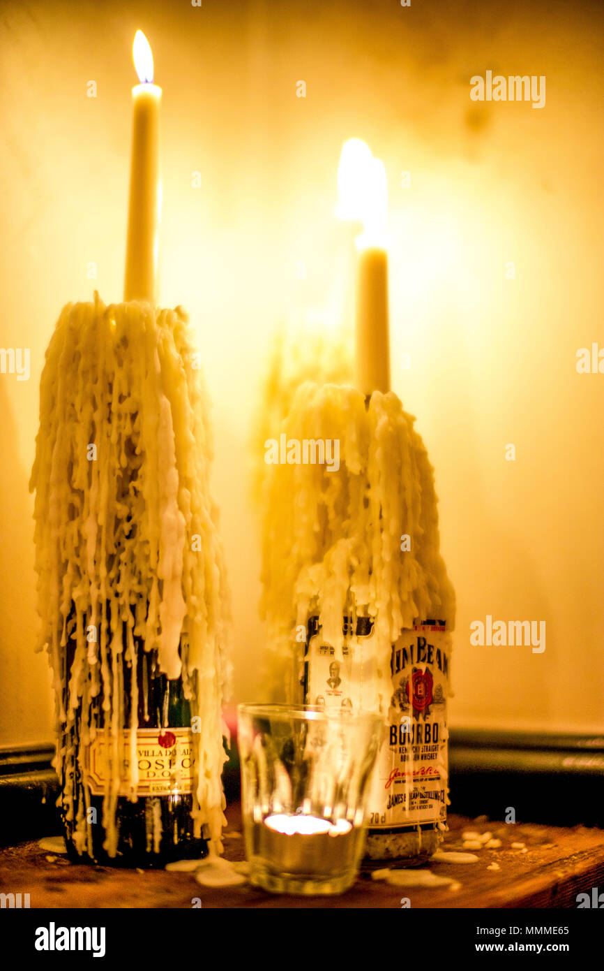 Deux bougies allumée dans les bouteilles de vin avec une grande quantité de  cire qui a coulé sur la bouteille Photo Stock - Alamy