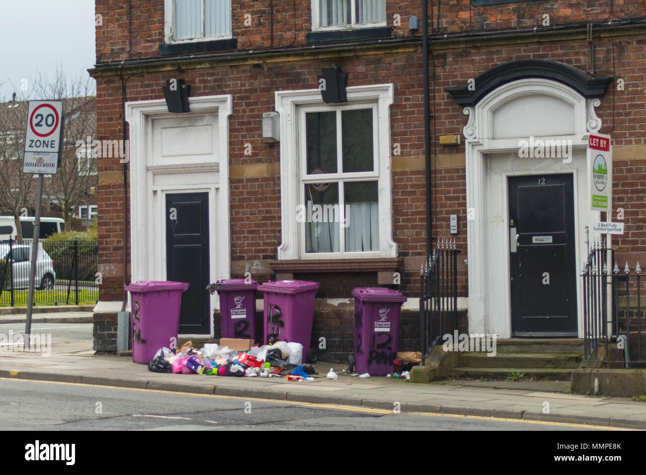Les bacs d'ordures Merseyside violet en face d'eux dans la rue Banque D'Images