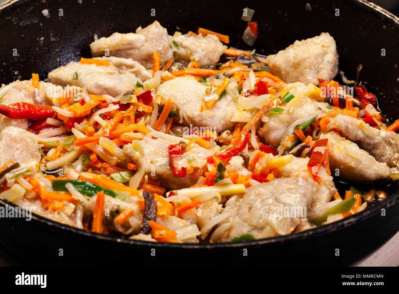 Des morceaux de porc avec un mélange de légumes chinois dans un wok casserole Banque D'Images